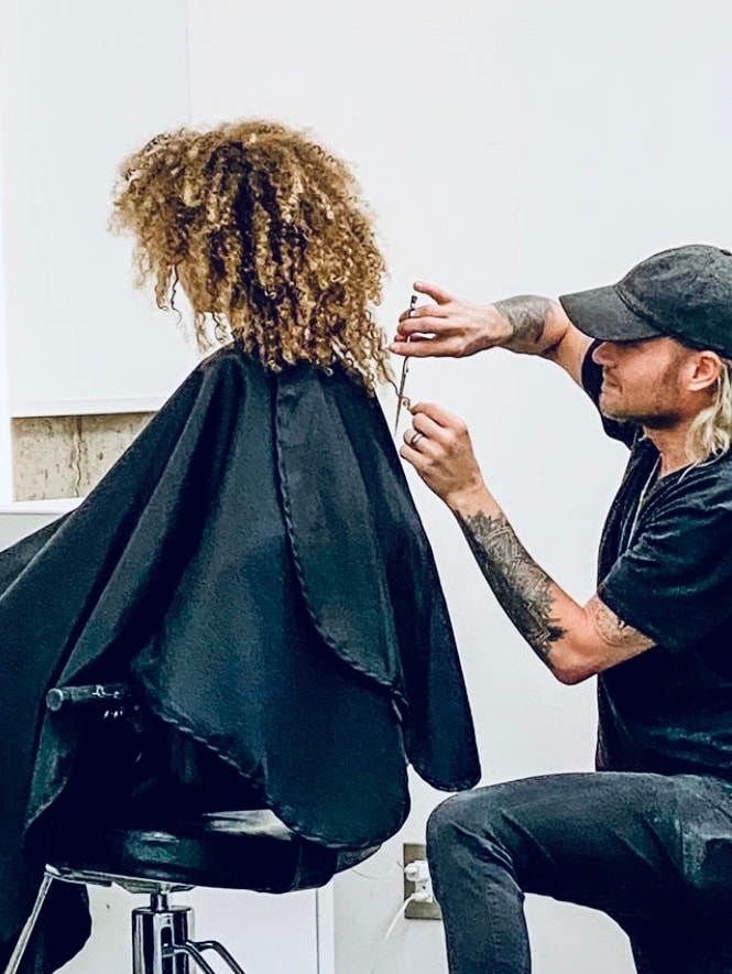 A master stylist at Tyson Daniel Hairdressing at work behind the chair